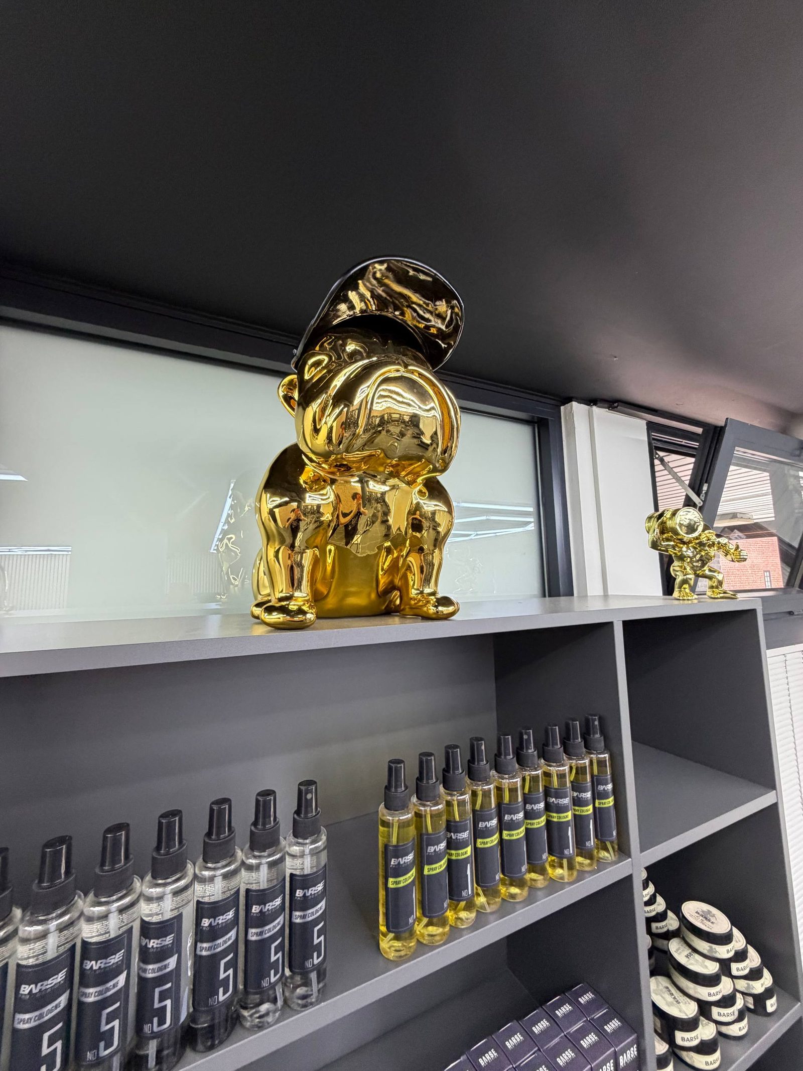 Sfeerbeeld in de zaak: gouden beelden boven de rij spray colognes